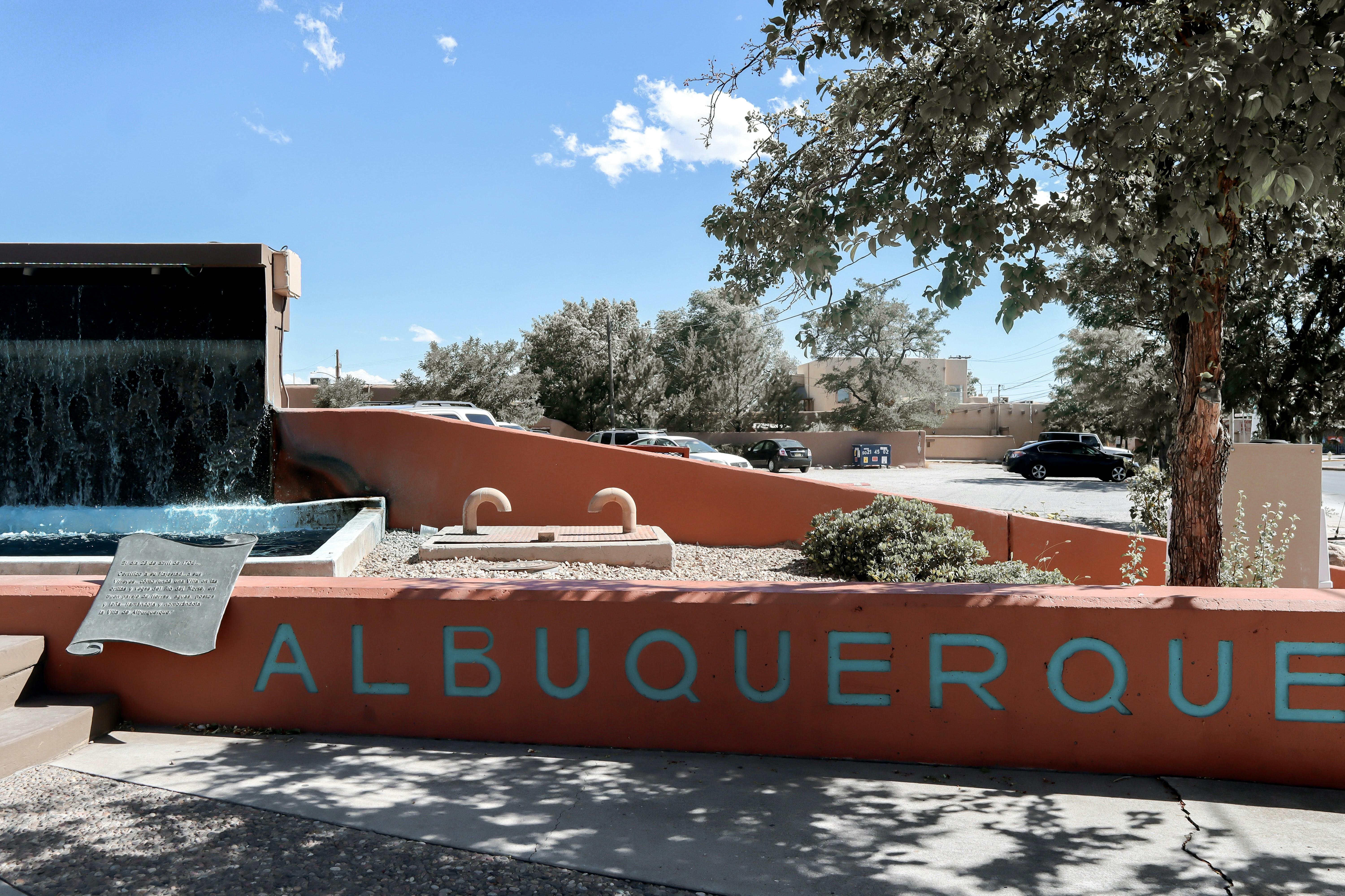 a sign that reads albuqueroque with a waterfall in the background